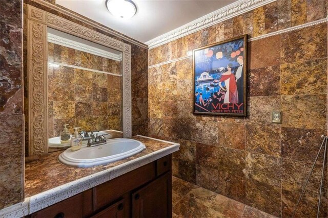 bathroom with vanity, tile walls, and ornamental molding