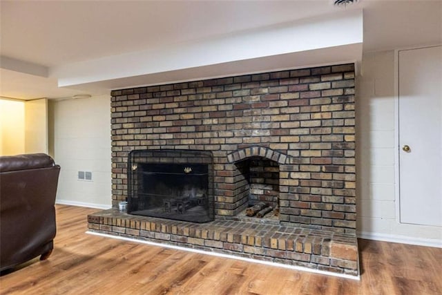 detailed view of wood finished floors, a fireplace, and baseboards