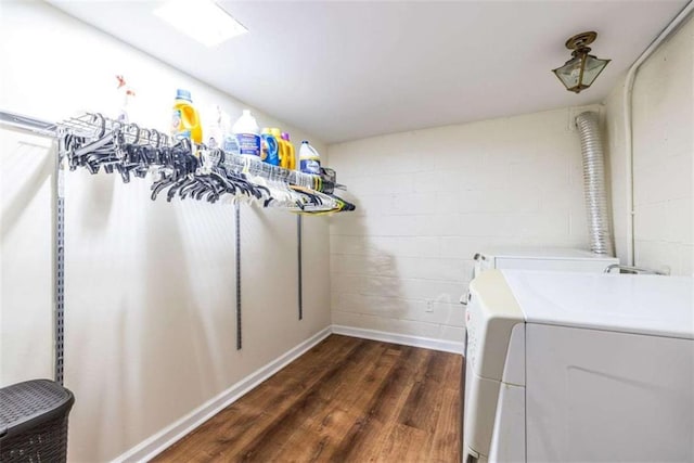 washroom with independent washer and dryer, dark wood-style floors, concrete block wall, and baseboards