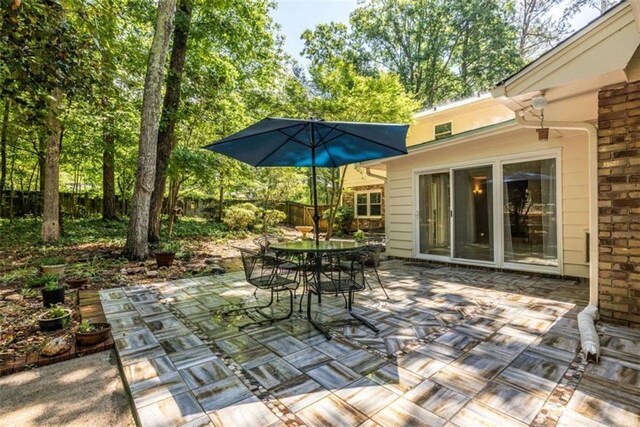 view of patio with outdoor dining space and fence