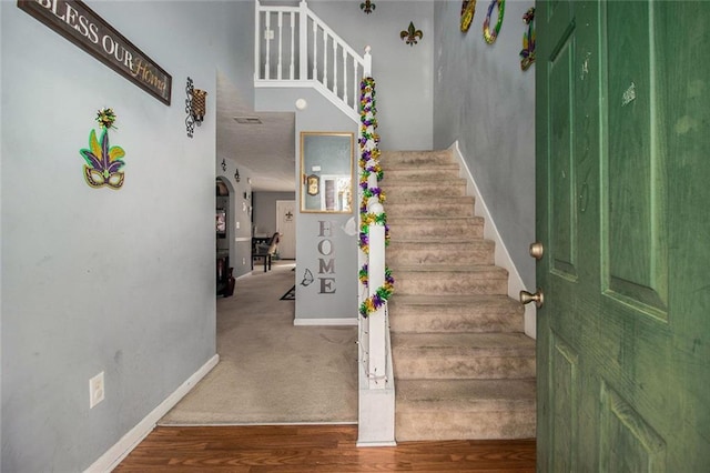 stairs with wood finished floors and baseboards