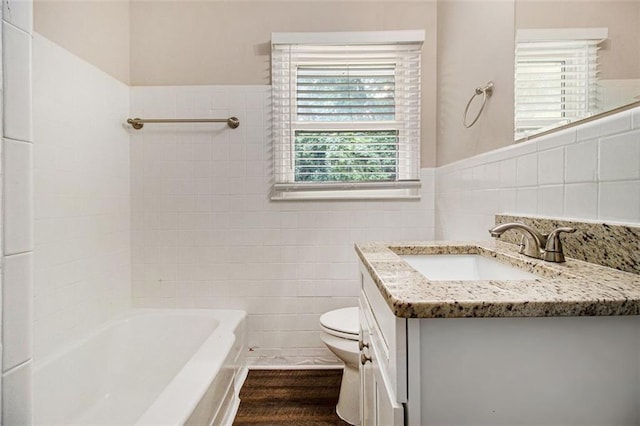 1955 Vicki Ln SE, Atlanta, GA 30316 - bathroom featuring tile walls, toilet, vanity, wainscoting, and  shower combination
