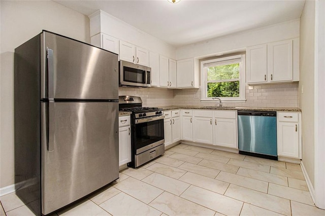 1955 Vicki Ln SE, Atlanta, GA 30316 - kitchen featuring appliances with stainless steel finishes, backsplash, white cabinets, and stone counters