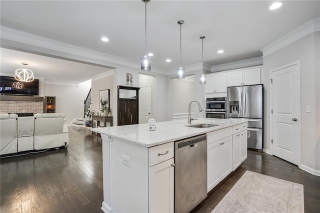 kitchen with light stone counters, dark wood-style flooring, stainless steel appliances, open floor plan, and a sink