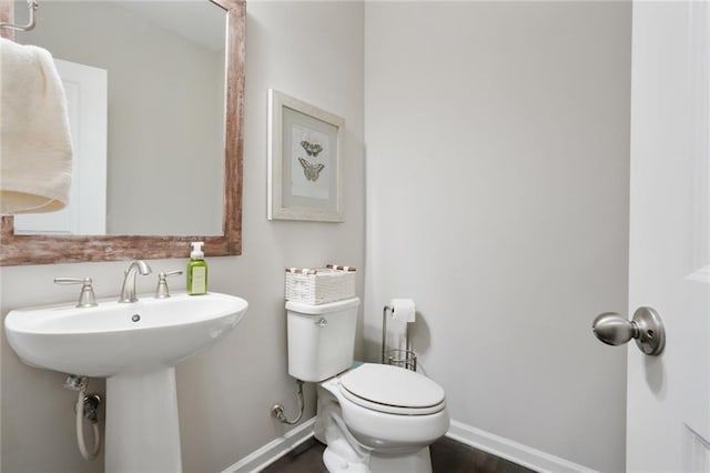 bathroom featuring a sink, toilet, and baseboards