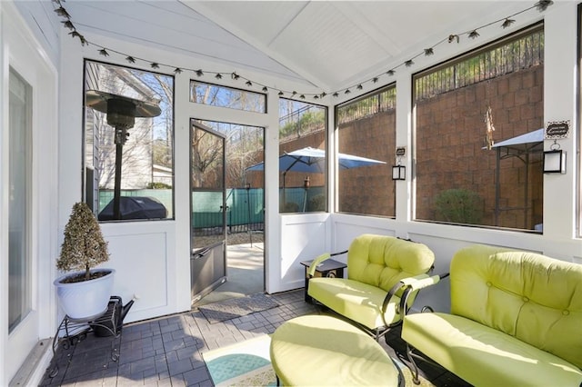 sunroom / solarium featuring vaulted ceiling