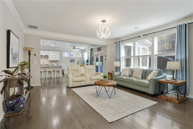 living area featuring baseboards, dark wood finished floors, visible vents, and crown molding