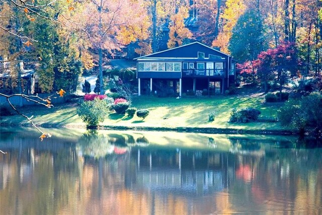 exterior space featuring a lawn and a deck with water view