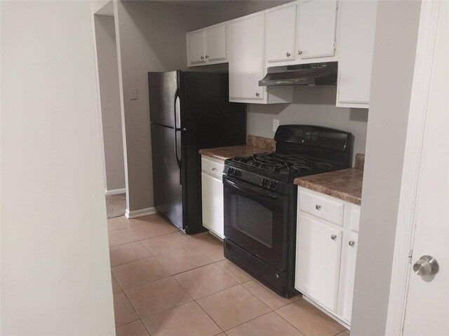 kitchen with light tile patterned floors, under cabinet range hood, dark countertops, white cabinets, and black appliances