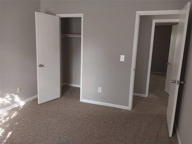 unfurnished bedroom with a closet, carpet flooring, and baseboards