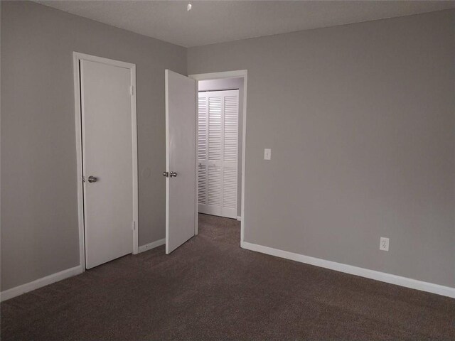 unfurnished bedroom featuring carpet floors and baseboards