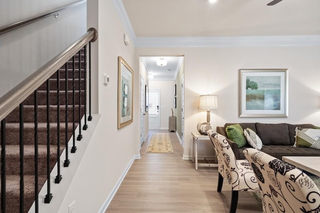 entrance foyer with light wood finished floors, stairs, baseboards, and ornamental molding