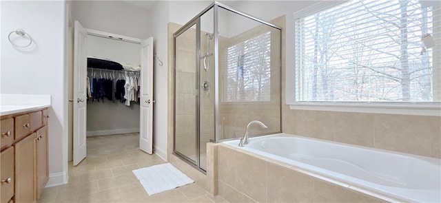 bathroom with tile patterned flooring, shower with separate bathtub, and vanity