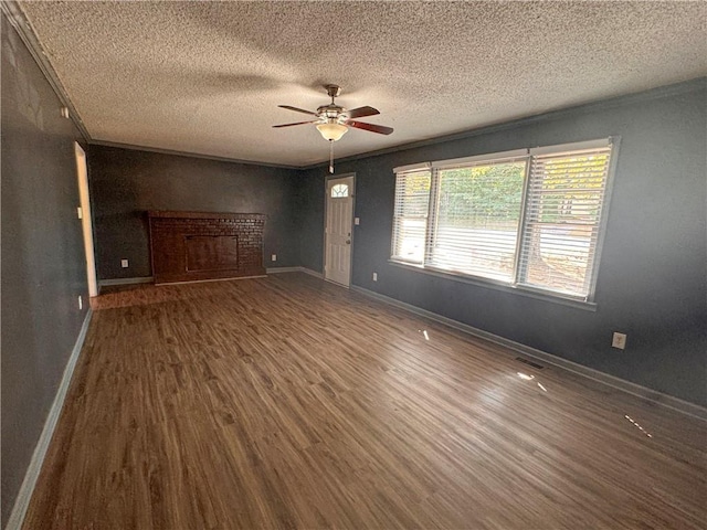 interior space featuring crown molding, dark hardwood / wood-style floors, a textured ceiling, and a fireplace