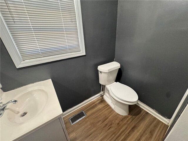 bathroom with vanity, hardwood / wood-style floors, and toilet