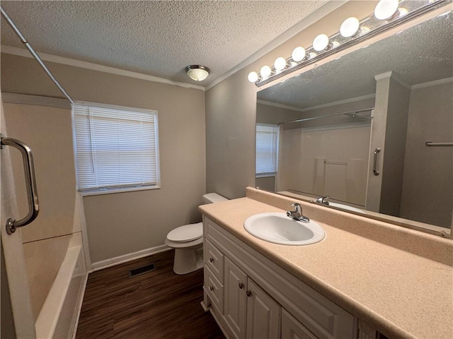 bathroom with hardwood / wood-style flooring, vanity, toilet, crown molding, and a textured ceiling