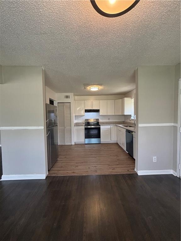 2830 Norgate Ln, Decatur, GA 30034 - kitchen featuring white cabinetry, light countertops, stainless steel appliances, dark wood-type flooring, and baseboards
