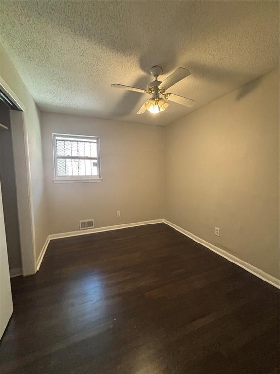 2830 Norgate Ln, Decatur, GA 30034 - empty room featuring a textured ceiling, dark wood-style floors, baseboards, visible vents, and ceiling fan