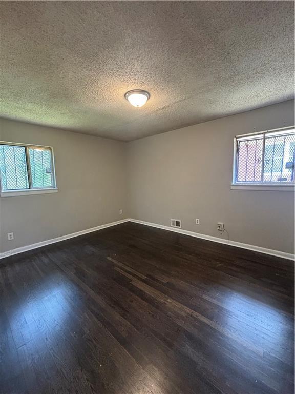 2830 Norgate Ln, Decatur, GA 30034 - empty room with dark wood finished floors, baseboards, visible vents, and plenty of natural light