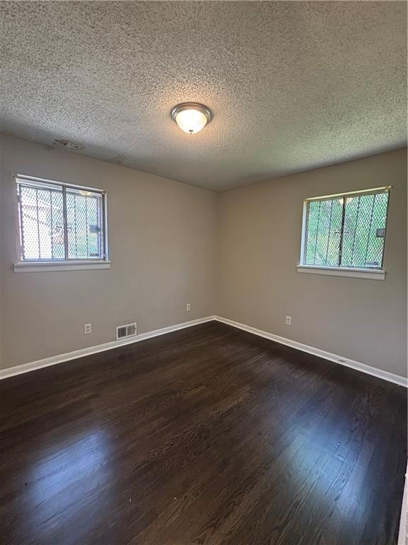 2830 Norgate Ln, Decatur, GA 30034 - empty room with baseboards, visible vents, a textured ceiling, and dark wood-style flooring