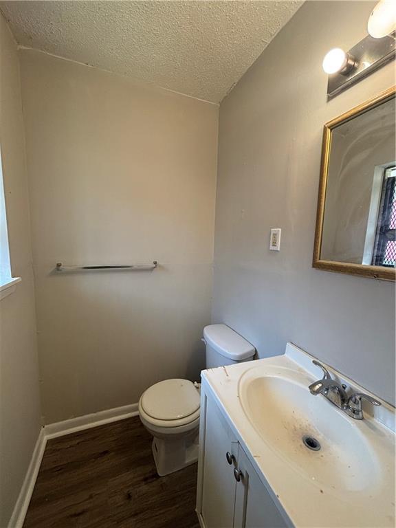 2830 Norgate Ln, Decatur, GA 30034 - bathroom with toilet, vanity, wood finished floors, a textured ceiling, and baseboards