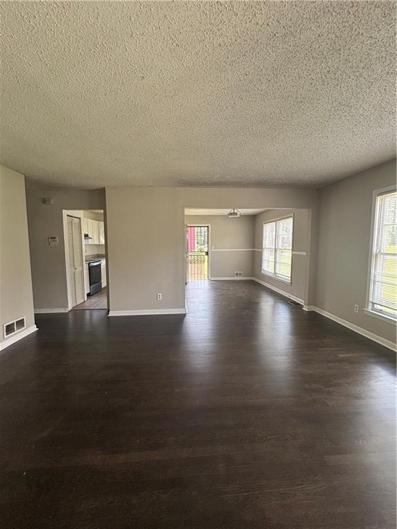 2830 Norgate Ln, Decatur, GA 30034 - unfurnished room with dark wood-type flooring, baseboards, a textured ceiling, and visible vents