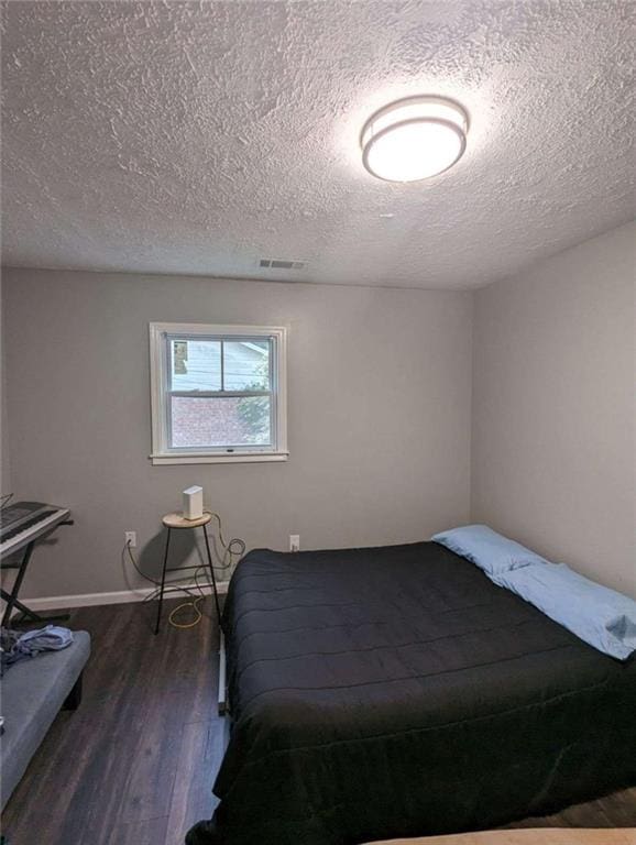 6977 Eunice Dr, Riverdale, GA 30274 - bedroom featuring dark hardwood / wood-style floors and a textured ceiling