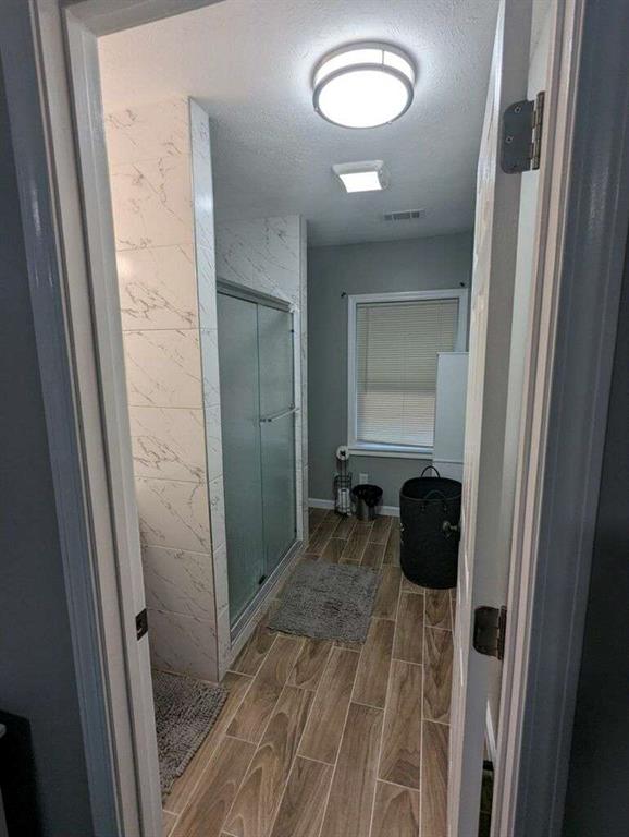 6977 Eunice Dr, Riverdale, GA 30274 - bathroom featuring a textured ceiling and walk in shower