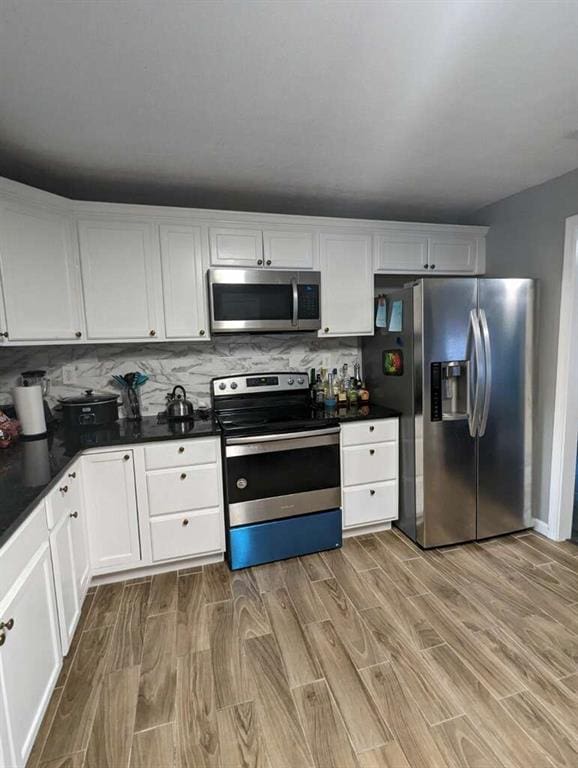 6977 Eunice Dr, Riverdale, GA 30274 - kitchen with backsplash, stainless steel appliances, light wood-type flooring, and white cabinets