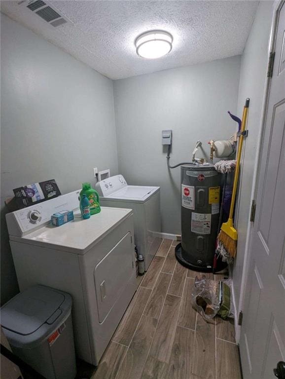 6977 Eunice Dr, Riverdale, GA 30274 - clothes washing area featuring washing machine and dryer, electric water heater, and a textured ceiling