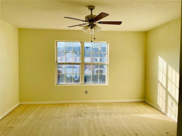 carpeted empty room featuring a ceiling fan, baseboards, and a textured ceiling