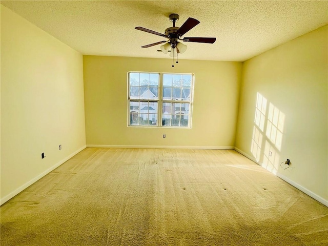 spare room featuring carpet, a ceiling fan, and a textured ceiling