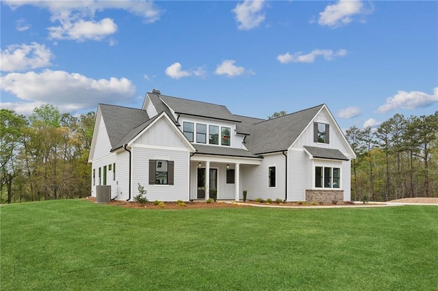 view of front of property with a front yard and central AC unit