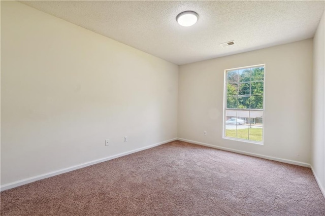 carpeted empty room featuring a textured ceiling