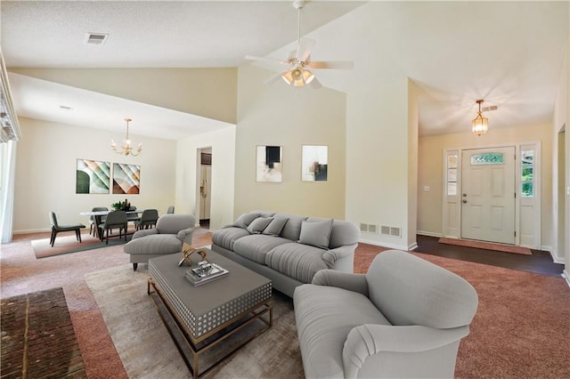 living room featuring ceiling fan with notable chandelier, high vaulted ceiling, and dark colored carpet