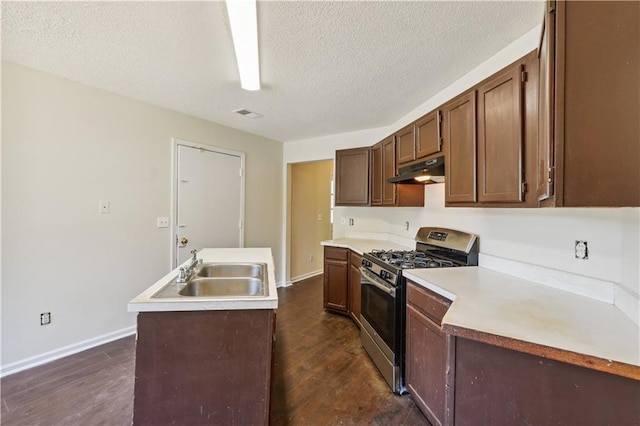 kitchen with dark hardwood / wood-style flooring, sink, stainless steel range with gas stovetop, and a textured ceiling