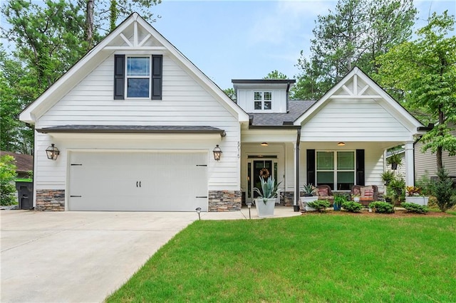 craftsman house featuring a porch, a garage, and a front lawn