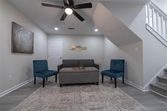 living area featuring wood-type flooring and ceiling fan