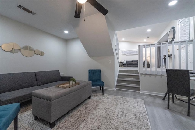 living room with ceiling fan, hardwood / wood-style floors, and vaulted ceiling