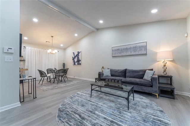 living room with vaulted ceiling with beams, hardwood / wood-style floors, and a notable chandelier