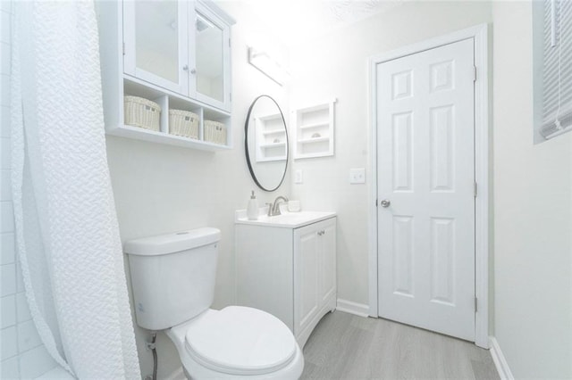 bathroom featuring curtained shower, vanity, wood-type flooring, and toilet