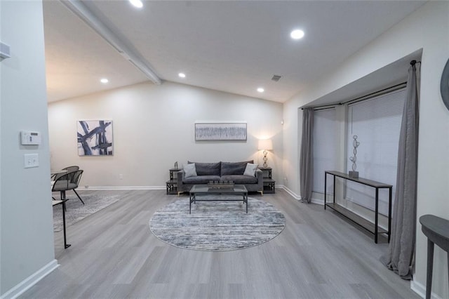 living room with lofted ceiling with beams and light hardwood / wood-style flooring