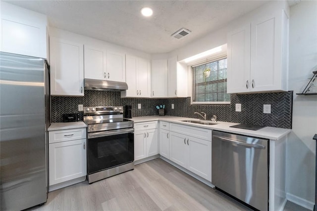 kitchen with white cabinetry, sink, light hardwood / wood-style flooring, and appliances with stainless steel finishes