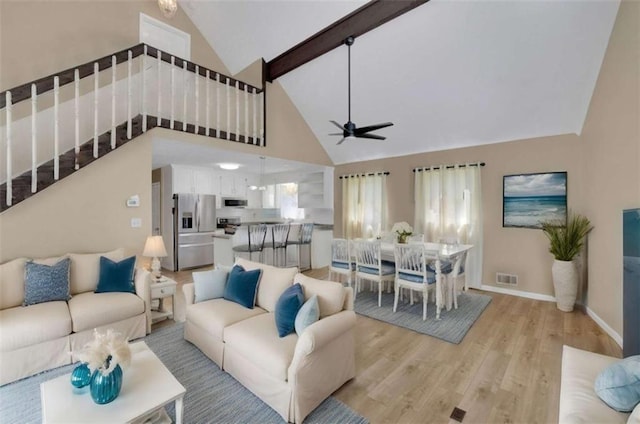 living room featuring high vaulted ceiling, light hardwood / wood-style flooring, and ceiling fan