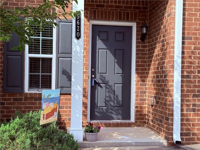 property entrance featuring brick siding