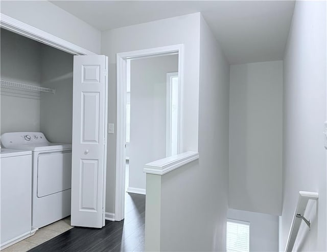 laundry room featuring washer and dryer and dark wood finished floors