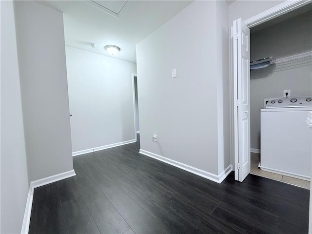 spare room with washer / clothes dryer, dark wood-style floors, and baseboards