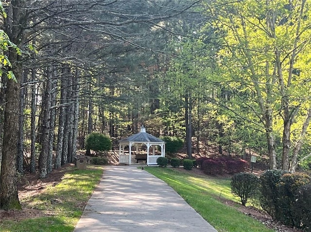 surrounding community featuring a gazebo, a forest view, and driveway