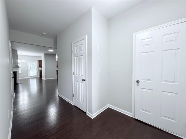 hallway with baseboards and dark wood-style floors
