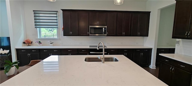 2962 Girard Ln, Duluth, GA 30097 - kitchen with stainless steel microwave, a sink, tasteful backsplash, and light stone countertops